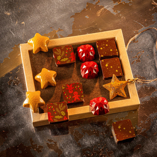 Wooden box with star-shaped chocolates on a textured surface