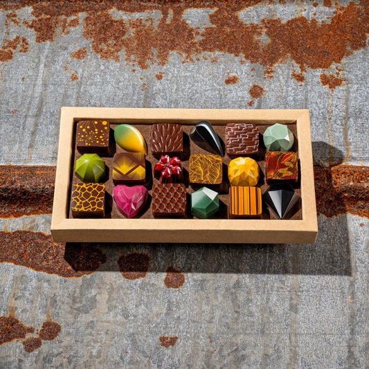 La feve's 18 assorted colorful chocolates box on a textured metal surface
