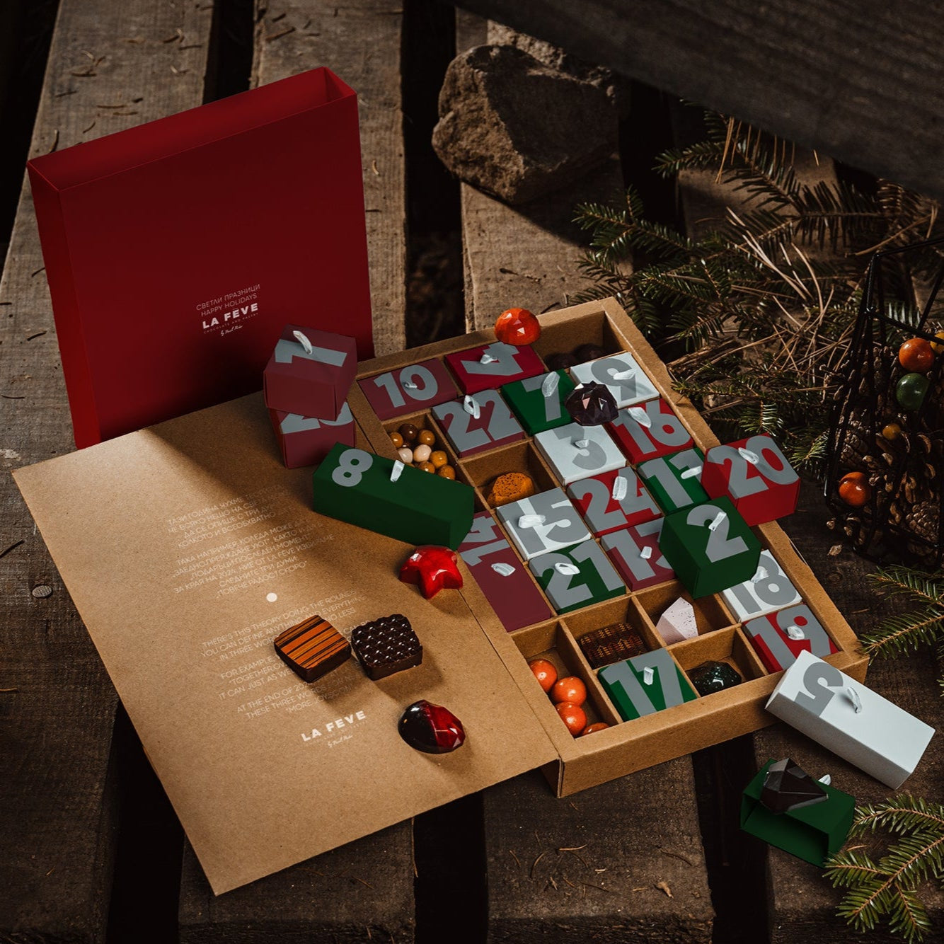 Open Christmas advent calendar with small gifts on a rustic wooden surface.