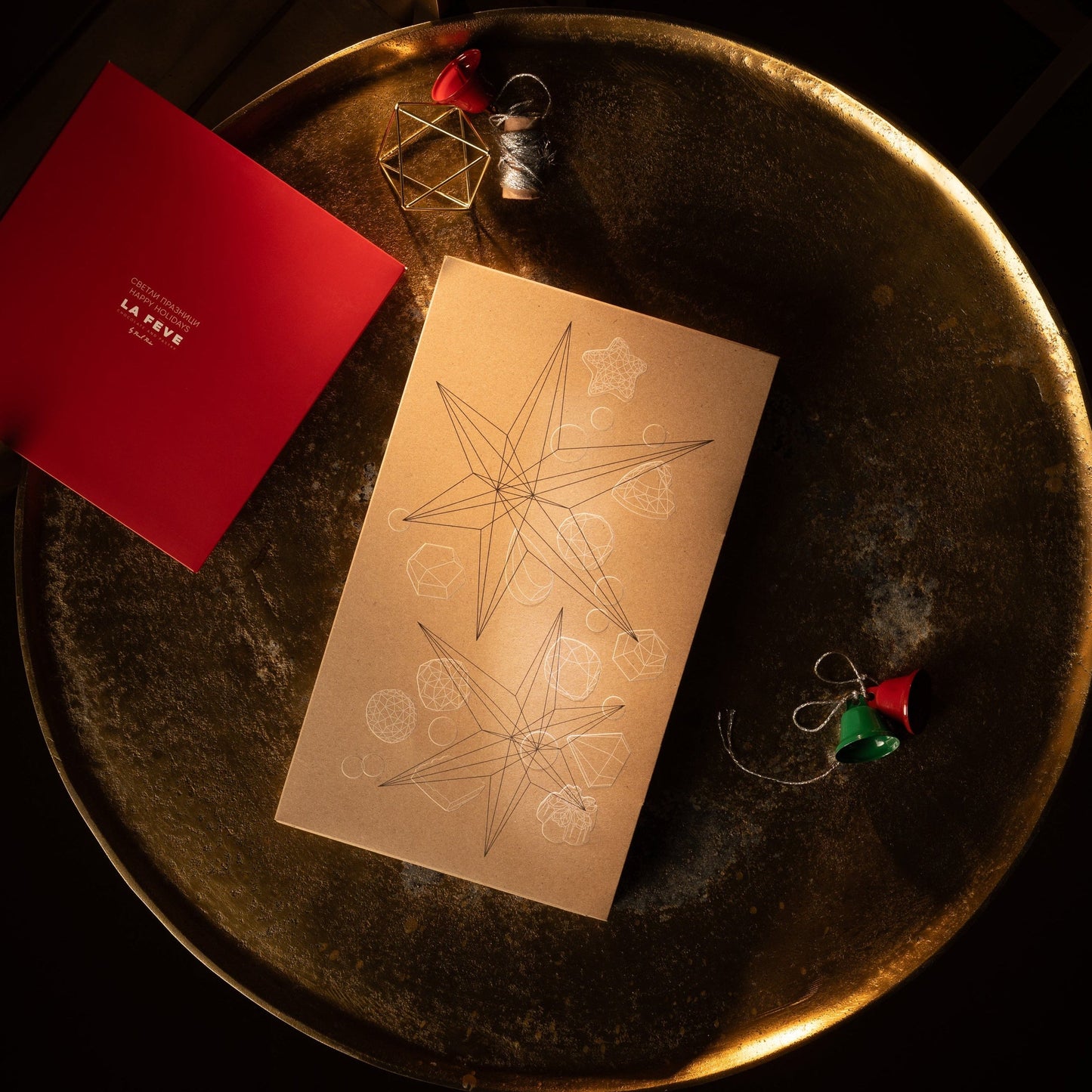 Red and beige eco-lux packaging on a dark surface with decorative elements.