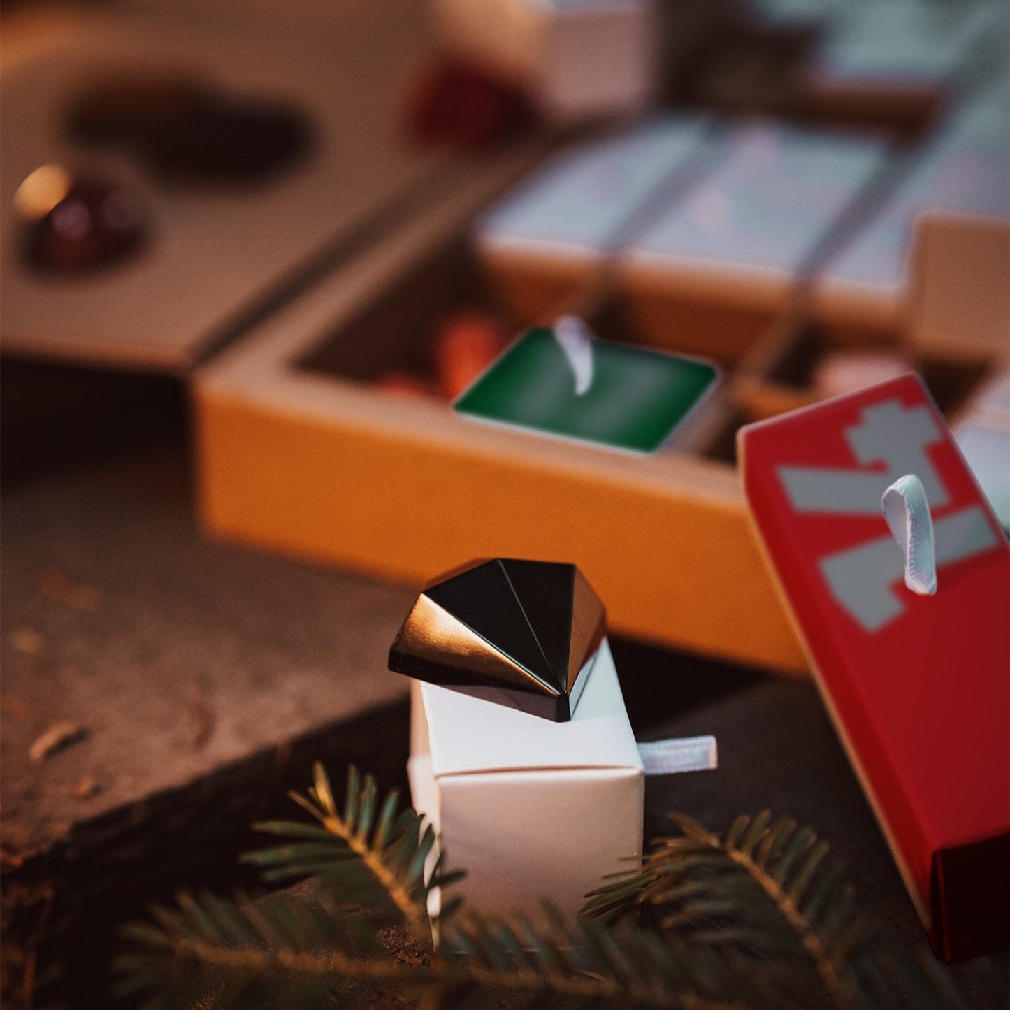 Small decorative candle with a metallic top on a table with blurred background