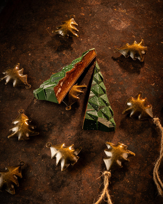 Origami-style tree chocolate with star-shaped decorations on a textured brown background
