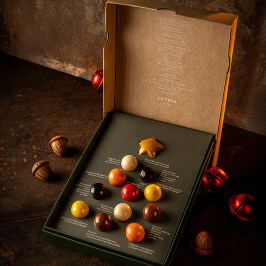 Assorted Christmas chocolate truffles in a box on a dark surface with a rustic background
