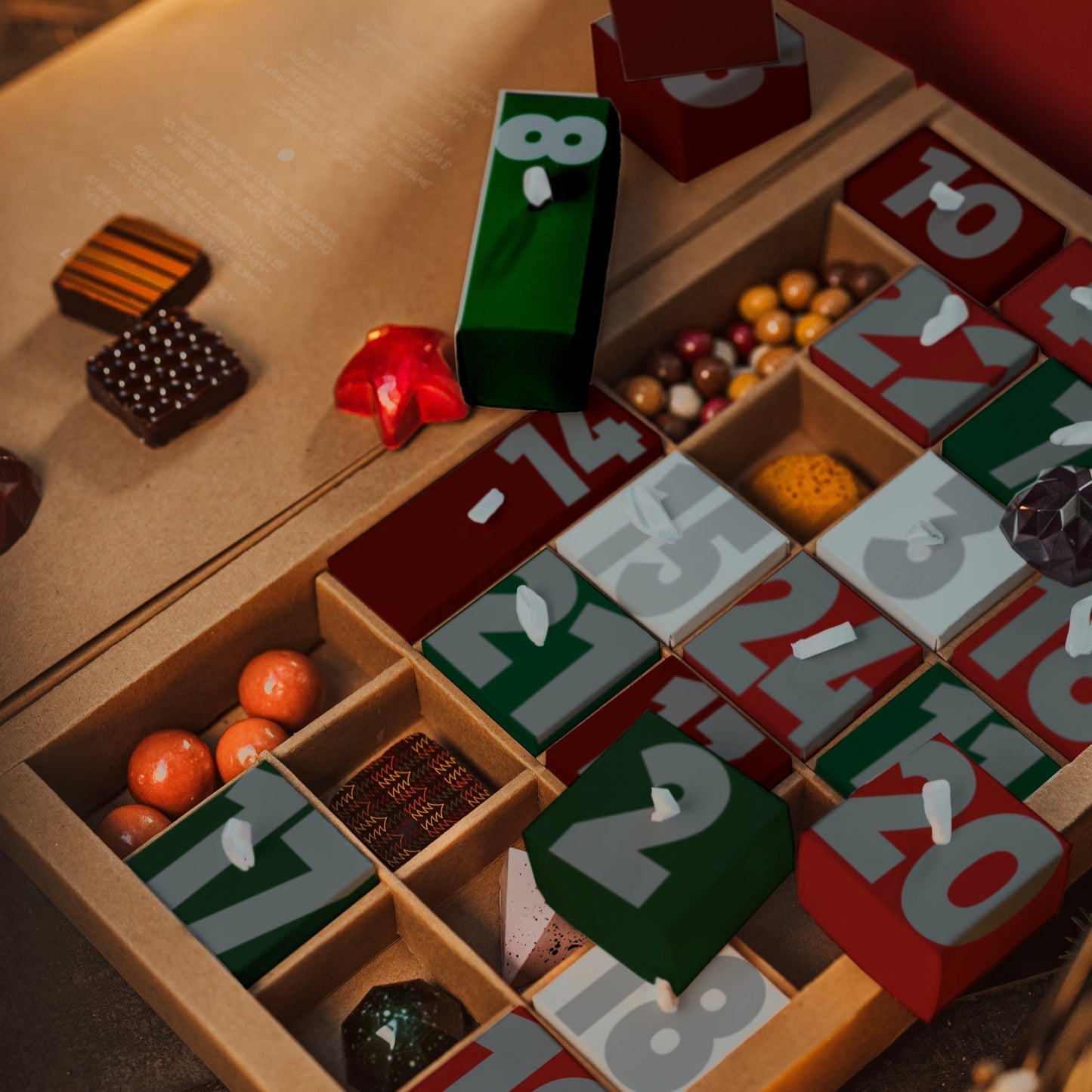 Wooden advent calendar with numbered sections filled with small chocolates on a wooden surface.