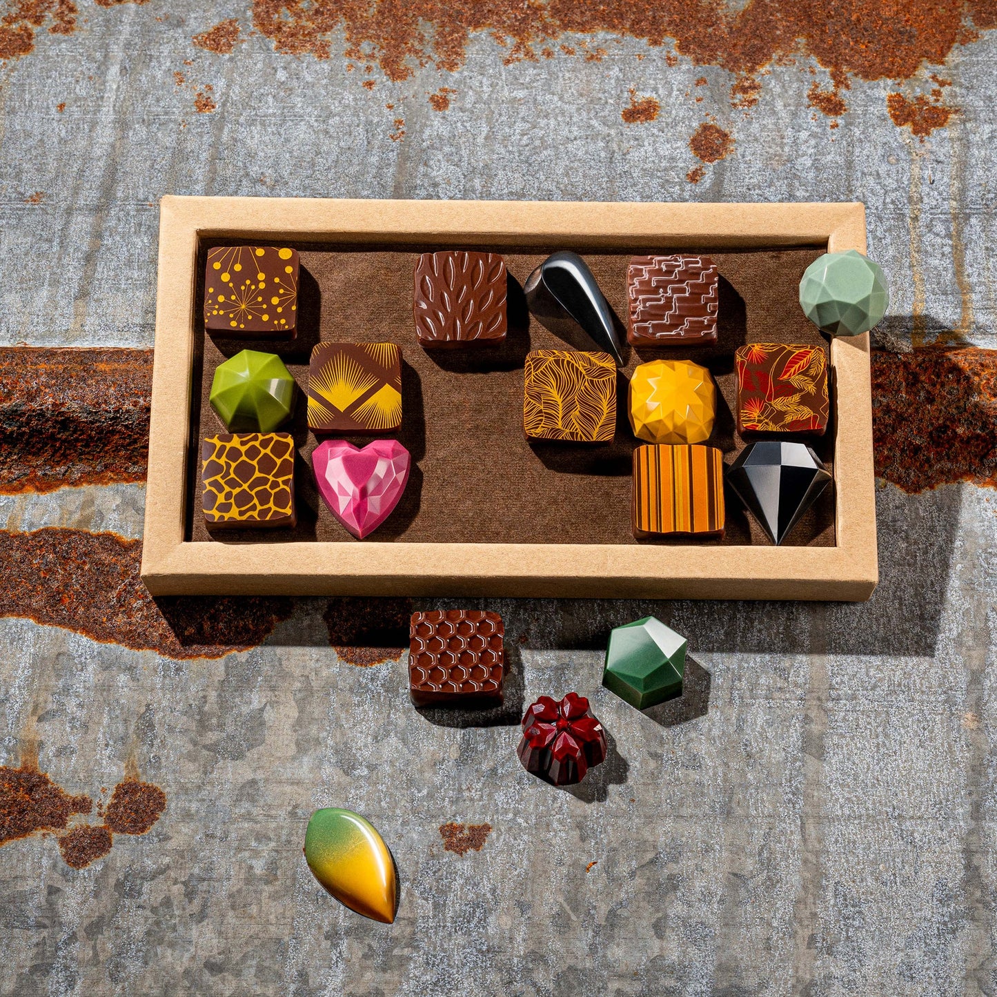La feve's 18 assorted colorful chocolates box on a textured metal surface