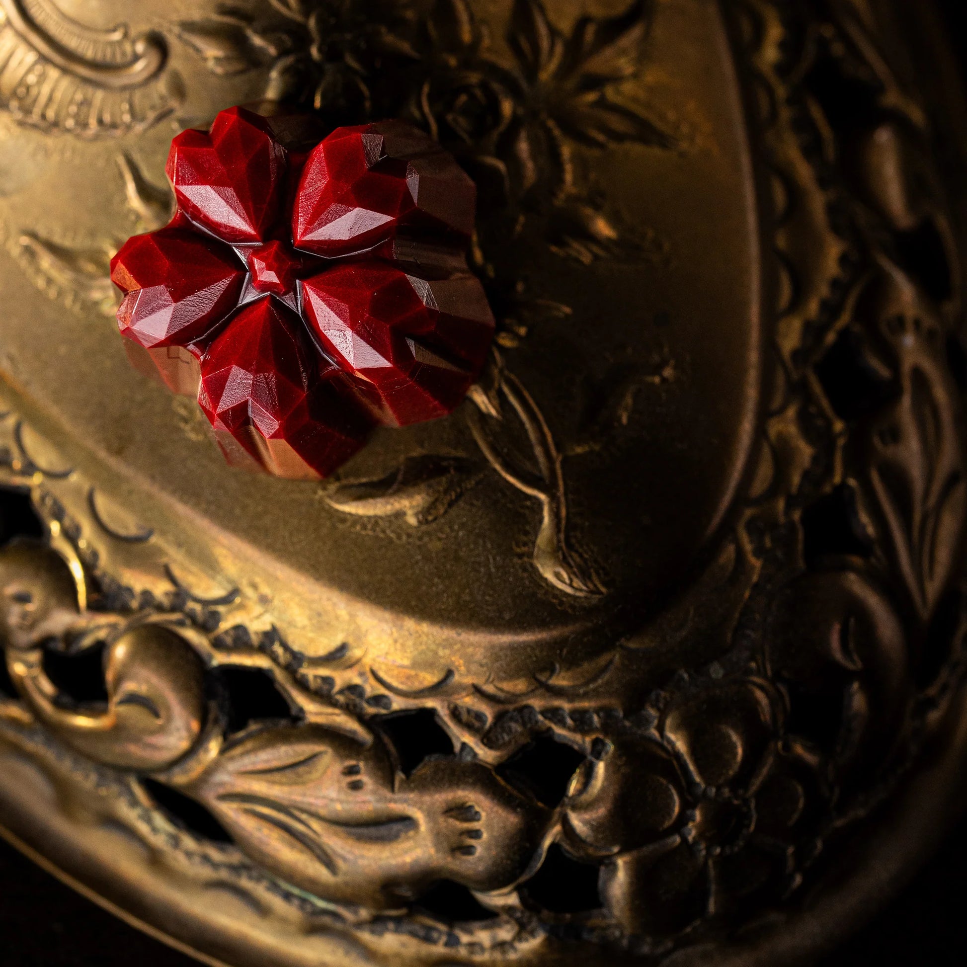 Red flower gemstons-like chocolate on an ornate gold background