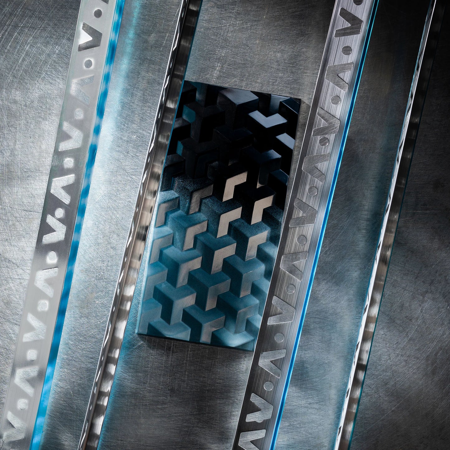 Teal chocolate bar with geometric design close up on a metal textured surface