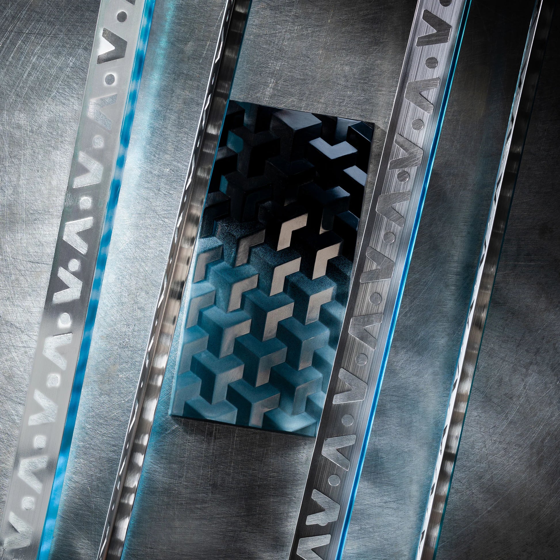 Teal chocolate bar with geometric design close up on a metal textured surface
