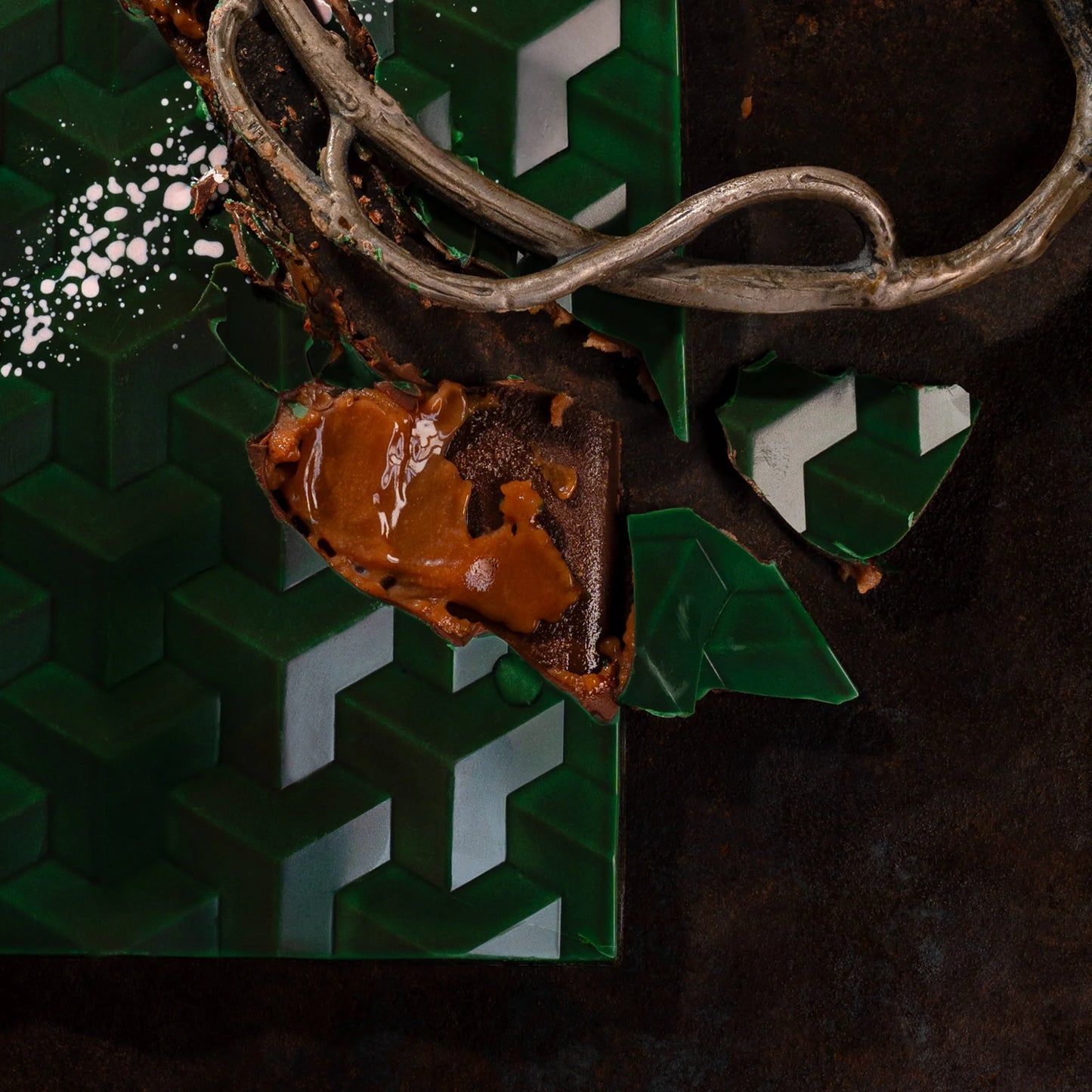 Close-up of a chocolate cookie with a caramel filling and decorative elements on a dark background